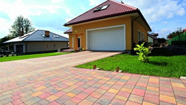 Do stworzenia podjazdów można wykorzystać różne materiały. Bardzo popularna jest kostka brukowa. Prezentujemy inspirujące rozwiązania. <br> Kostka brukowa Granito; wymiary: 9/10 x 16, 13/12 x 16, 16/17 x 16, 21/20 x 16 cm; grubość - 6 cm; kolory: Linia Styl - indiana, latte, hawaii; faktura: gładka; <b>cena: 55 zł/m2</b> materiały na nawierzchnie