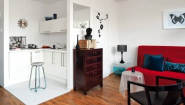 Mieszkanie. Dzięki przeniesieniu wejścia do łazienki do pokoju w malutkiej kuchni można było zabudować szafkami dwie ściany. Chociaż nie ma tu zbyt wiele miejsca, w jednej z szafek udało się ukryć pralkę.