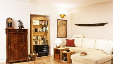 W kąciku wypoczynkowym wokół nowoczesnej kremowej kanapy można dostrzec wiele oryginalnych przedmiotów: pachnącą cygarami kubańską szafeczkę, metalowy egipski gong. W kąciku wypoczynkowym wokół nowoczesnej kremowej kanapy można dostrzec wiele oryginalnych przedmiotów: pachnącą cygarami kubańską szafeczkę, metalowy egipski gong.