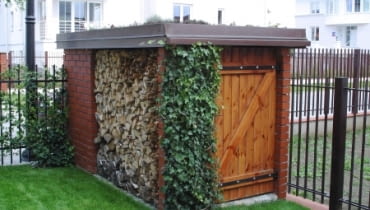 Dwa w jednym: składzik gospodarczy z miejscem na drewno do kominka oraz śmietnik dostępny od strony ulicy.