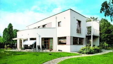 Bryła domu z prostym dachem jest oszczędna. Na elewacjach zastosowano boniowanie, aby nieco przełamać jej surowość. Z trzech stron wzbogacono ją również tarasami