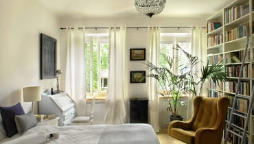 Przy łóżku stoi jedna z lamp z IKEA, od których zaczęły się zmiany jeszcze w poprzednim mieszkaniu. Fotel uszak z lat sześćdziesiątych należał do babci Magdy - była w nim często portretowana przez swojego męża. Żyrandol trafił tu z warszawskiego targu staroci na Kole. sypialnia, aranżacja sypialni, vintage