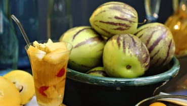 Koktajl z kawałkami gruszki melonowej - pepino </Br>6 dużych owoców pepino łyżeczka miodu 250 ml soku z ananasa sok z połowy limonki kilka wisienek koktajlowych Jeden owoc gruszki melonowej (pepino) odłożyć, a pozostałe oczyścić i wycisnąć z nich sok w sokowirówce. Sok z pepino wymieszać z sokiem ananasowym, miodem i sokiem z limonki. Pozostały owoc obrać, oczyścić i pokroić jego miąższ w kosteczkę. Wysokie szklaneczki napełnić kawałkami gruszki melonowej i wisienkami. Zalać sokiem. Podawać mocno schłodzone. (Przepis na 4-6 porcji) Pepinos in bowl and pepino cocktail (Solanum muricatum)