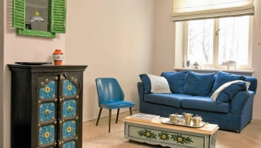 Urządzając swoje pierwsze mieszkanie, pani Patrycja wymarzyła sobie oryginalną tapetę. O pomoc w jej sprowadzeniu z Londynu poprosiła mieszkającego tam Sebastiana, kolegę ze szkoły, którego nie widziała od trzynastu lat. Niecały rok później byli małżeństwem, a tapeta zdobi teraz ich wspólne gniazdko w starej warszawskiej kamienicy. <BR /> MIESZKANIE. Ciekawe zestawienie - przy nowoczesnej kanapie w pokoju dziennym stoi stolik kawowy o rustykalnym charakterze, zrobiony... ze starej skrzyni na kwiaty. Gospodyni dorobiła do niej blat z kawałka deski i zamontowała kółka, a potem ozdobiła mebelek kwiatowym motywem. Pasuje do niego lustro w ramie wzorowanej na okiennicach i malowana egzotyczna komódka z palisandru.