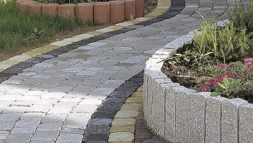 Falista ścieżka z szaro-grafitowej kostki betonowej ścieżki w ogrodzie, nawierzchnia w ogrodzie, kostka betonowa