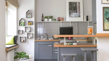 PO ZMIANIE. Wisząca półka nad półwyspem została zrobiona z metalowych rurek i blachy według projektu architektów. To element wyłącznie dekoracyjny - światło ustawionych tu świec tworzy wieczorem miły nastrój. kuchnia, metamorfoza kuchni, meble kuchenne