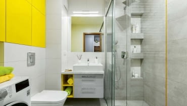 Wnękowe półki w kabinie prysznicowej celowo rozmieszczono na różnej wysokości - dzięki temu mogą z nich wygodnie korzystać i duzi, i mali. Warto dodać, że takie półki są bezpieczne i dla domowników (nie uderzą się o wystające elementy), i dla ustawionych na nich kosmetyków (nie spadną na podłogę). Na podłodze położono gresowe płytki Timbre Grey, na ścianach - Timbre White i Timbre cement; przy kabinie wkomponowano szklaną listwę Yellow (wszystko z firmy Tubądzin). Wnękowe półki w kabinie prysznicowej celowo rozmieszczono na różnej wysokości - dzięki temu mogą z nich wygodnie korzystać i duzi, i mali. Warto dodać, że takie półki są bezpieczne i dla domowników (nie uderzą się o wystające elementy), i dla ustawionych na nich kosmetyków (nie spadną na podłogę). Na podłodze położono gresowe płytki Timbre Grey, na ścianach - Timbre White i Timbre cement; przy kabinie wkomponowano szklaną listwę Yellow (wszystko z firmy Tubądzin).