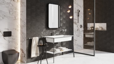 Minimalistyczna czarna konsola doskonale uzupełnia wystrój łazienki, nie odciągając uwagi od ciekawie zdobionych płytek, nowoczesnego lustra czy oryginalnego oświetlenia