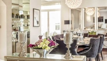 Atmosferę strefy dziennej budują wysmakowane detale, kwiaty, eleganckie stoliki, szkła zastawy stołowej i barku oraz starannie dobrane obrazy. elegancki dom, eleganckie wnętrza, jak urządzić elegancki dom
