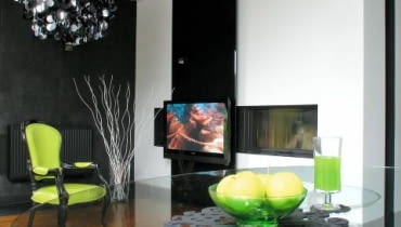 <b> MINIMALIZM Z DUSZĄ. Chłodna nowoczesność ocieplona starannie dobranymi drobiazgami utrzymywanymi w starym stylu. Czarno-biała kolorystyka ożywiona energetycznymi zielonymi dodatkami. Projektanci wykazali się konsekwencją naprawdę godną pochwały. </b> <BR /> Telewizor jest zainstalowany na ruchomym szklanym panelu, którego kąt można ustawiać w zależności od potrzeby. Można też zasłonić nim drzwiczki kominka. OLYMPUS DIGITAL CAMERA