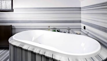 Owalną wannę, zainstalowaną w rogu pomieszczenia, otacza marmurowy blat. Można na nim postawić wszystkie rzeczy potrzebne podczas kąpieli. WNETRZA LAZIENKA