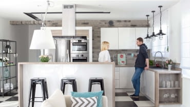 Kuchenne szafki zrobiono na zamówienie. Lakierowane białe fronty połączono z fornirem wybarwionym na kolor laminowanych paneli na podłodze (wzór dąb lancashire firmy Sensa). Fragmenty ścian są wyłożone popielatą cegłą - zdaniem gospodarzy taki odcień ociepla wnętrze.