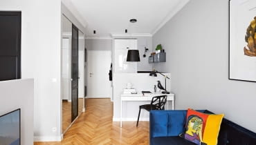 Malutkie wnętrze zostało podzielone. Projektantka zrezygnowała jednak z typowych ścian, które zabrałyby cenną przestrzeń - zamiast nich są szafy, niewysokie ścianki działowe i przesuwająca się zasłona. Malutkie wnętrze zostało podzielone. Projektantka zrezygnowała jednak z typowych ścian, które zabrałyby cenną przestrzeń - zamiast nich są szafy, niewysokie ścianki działowe i przesuwająca się zasłona.