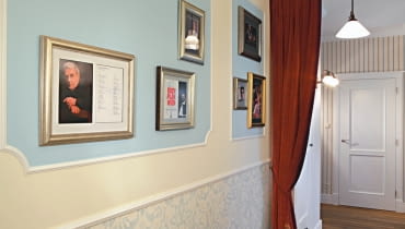 <B>Nie dość, że przedpokoje są zazwyczaj niezbyt duże i wąskie, to w dodatku funkcjonalne zagospodarowanie przestrzeni utrudniają liczne drzwi. Planując liczbę i wielkość ewentualnych szaf, musimy pamiętać o tym, że przedpokój pełni przede wszystkim ważną funkcję komunikacyjną, nie może więc być nadmiernie zastawiony meblami. Za minimalną szerokość przejścia przyjmuje się 120 cm.</B> <BR >MIESZKANIE. PRZEDPOKÓJ JAK W TEATRZE. Każdy, kto przestępuje próg tego mieszkania, od razu wie, jakie są pasje i upodobania gospodarzy. To, że kochają operę i starą Anglię, zdradza aranżacja przedpokoju wystylizowanego w najdrobniejszych szczegółach na dawne wiktoriańskie wnętrze. Wyraźne są tu również nawiązania do teatralnego foyer. W polach wyznaczonych przez fantazyjne obramowanie z listew sztukateryjnych i pomalowanych jasnobłękitną farbą wyeksponowano fotografie słynnych śpiewaków operowych opatrzone ich autografami. Tę kolekcję zbierał latami pan domu, wielki miłośnik opery.