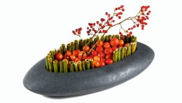 Japońskie natchnienie. I znów niewymuszona prostota - z czarnym naczyniem skontrastowano czerwonerajskie jabłka i owoce róży wielokwiatowej (Rosa multiflora). Brzegi 'wyrysowano' pociętym na kawałki pędami rdestu (najprościej umocować je w gąbce, którą wyłożono naczynie, lub połączyć drutem). 26.09.2008 WARSZAWA