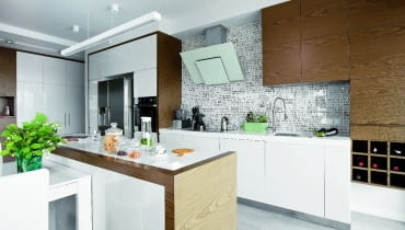 Tapetę nad kuchennym blatem zakryto szklaną taflą. Dzięki temu okładzina się nie zniszczy.