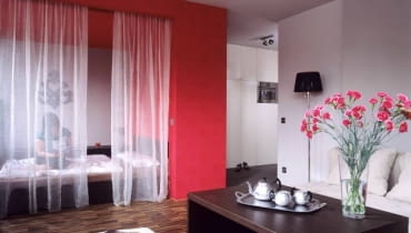 Aranżacje. W tym mieszkaniu najważniejszym meblem jest łóżko. O jego randze świadczy fakt, że zajęło miejsce, gdzie poprzednio była kuchnia, którą teraz urządzono w przedpokoju. Niewielkie mieszkanie znajdujące się w nowo zbudowanym bloku Karolina chciała urządzić nowocześnie, ale także bardzo kobieco. Projektanci zaproponowali więc meble o prostych kubicznych formach, które złagodzili oświetleniem i akcentami czerwieni - ulubionego koloru właścicielki. Meble i dekoracje zostały ograniczone do minimum. UWAGA ! PONOWNA PUBLIKACJA WYLACZNIE ZA ZGODA WLASCICIELI
