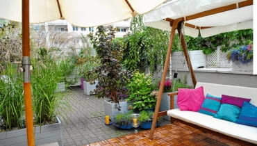 WIDOK TARASU Z KĄCIKA KAWOWEGO. Na pierwszym planie drewniana huśtawka, w głębi podniebna "plaża".