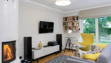 W EKLEKTYCZNYM SALONIE znalazło się miejsce zarówno dla metalowego stolika w stylu glamour, jak i prostej szafki z IKEA czy loftowej lampy stojącej. Nowoczesny grzejnik ukryto za estetyczną ażurową przesłoną. salon, aranżacja salonu
