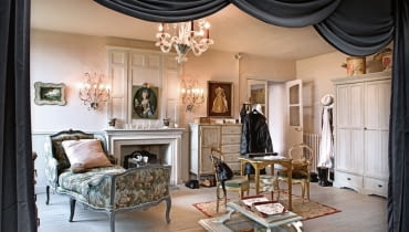 Sypialnia w klimacie buduarowo-teatralnym. Trochę jak scena, którą kurtyna dzieli na dwie części: właściwą z łóżkiem (widocznym na następnej stronie) i wypoczynkową z niezastąpionym szezlongiem. Pod sufitem klasyczny żyrandol murano. dom, dom we Francji, projektanci