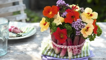 Bukiecik w rzodkiewkowej oprawie będzie niecodzienną ozdobą ogrodowego przyjęcia, a jego przygotowanie nie zajmie wiele czasu. Uwaga: zamiast rzodkiewek można wykorzystać małe marchewki lub liście kapusty (włoskiej, czerwonej). Glasschale als Vase verkleidet mit Radieschen : Strauss aus Tropaeolum ( Kapuzinerkresse ), Oregano ( Origanum ) und Petersilie ( Petroselinum ) in mit Radieschen ( Raphanus ) verkleidetem Glas SLOWA KLUCZOWE: Kr uter Praxis Step essbare Bl´ten Gem´se FERTIGBILD rot ROSA FARBE gelb 000 msgnp13 Sommer draussen quer FLORISTIK