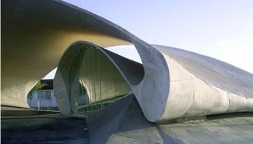 Przystanek autobusowy w Casar deCaceres w Hiszpanii. autor: Justo Garcia Rubio Arquitecto. Przystanek w hiszpańskim mieście Casar de Cáceres to zupełne przeciwieństwo ortogonalności, do której jesteśmy przyzwyczajeni. Architekci pokusili się o bardzo oryginalną i delikatną strukturę, w której podłogi, ściany i dach są jednym, płynnie przekształcającym się, falującym elementem. Bardzo dynamiczna forma i minimalizm użytych materiałów powodują, że przystanek można odbierać bardziej w charakterze rzeźby niż elementu małej architektury. Kojarzy się z zastygniętą wstęgą, tworzącą uroczysty baldachim. mała architektura, mała bryła, hiszpania, Justo Garcia Rubio, Casar deCaceres