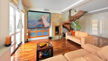 Gospodarze kochają podróże, co znalazło odzwierciedlenie w wystroju domu. Do ich wojaży po bliższych i dalszych zakątkach świata nawiązują nie tylko rozstawione po całym wnętrzu pamiątki, ale także egzotyczne gatunki drewna i... kolorystyka błękitnej jak ocean sypialni. <BR /> DOM. Ściana ciekawie zaaranżowana. Okno przesłonięte ekranem, na którym gospodarze oglądają filmy z projektora, to w rzeczywistości wbudowany w ścianę regał. Dwanaście frontów z  mlecznego szkła ujęto w ramę z palisandru. Tym samym materiałem obramowano palenisko kominka wyłożonego płytami wielobarwnego łupka. Na podłodze - orzech amerykański. Gospodarze kochają podróże, co znalazło odzwierciedlenie w wystroju domu. Do ich wojaży po bliższych i dalszych zakątkach świata nawiązują nie tylko rozstawione po całym wnętrzu pamiątki, ale także egzotyczne gatunki drewna i... kolorystyka błękitnej jak ocean sypialni. <BR /> DOM. Ściana ciekawie zaaranżowana. Okno przesłonięte ekranem, na którym gospodarze oglądają filmy z projektora, to w rzeczywistości wbudowany w ścianę regał. Dwanaście frontów z  mlecznego szkła ujęto w ramę z palisandru. Tym samym materiałem obramowano palenisko kominka wyłożonego płytami wielobarwnego łupka. Na podłodze - orzech amerykański.