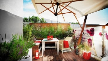<B>Wystarczyły dwa tygodnie, by taras z betonu i stali na dachu budynku w środku miasta zmienił się w cichy, idylliczny zakątek, w którym gospodarze czują się jak na wiejskiej łące. Skąd takie wrażenie? Wywołują je użyte materiały, zwłaszcza naturalne drewno, oraz doniczkowe rabatki skomponowane z kwitnących wśród traw delikatnych roślin.</B> <BR /> METAMORFOZA TARASU. Płotek zasłania widoczną z tarasu konstrukcję dachu i zapewnia bezpieczeństwo. Zrobiono go z thermojesionu (dzięki obróbce w wysokiej temperaturze drewno ciemnieje i nabiera odporności). <BR /> Meble ze sztucznego rattanu są odporne na deszcz i śnieg, dzięki czemu nie trzeba ich przenosić na zimę do mieszkania. Rozłożony w upalne dni parasol daje upragniony cień. <BR /> Na ekranie z pleksi nadrukowano bordowe kwiaty zawciągu nadmorskiego. Ekran nie tylko zdobi taras, ale również chroni domowników przed wzrokiem sąsiadów i zasłania widok na miasto. taras, metamorfoza, aranżacja tarasu, balkon, meble na balkon