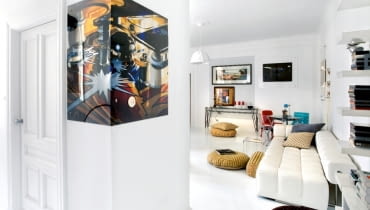 Na narożniku szafy nietypowo zamontowana reprodukcja obrazu 'Pin Ball' Charlesa Bella. Biała sofa marki Iker, lampa Successful Living marki Diesel Home Collection. Obicia poduch szyte ręcznie przez właścicielkę.