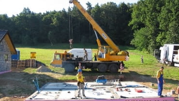 Budowa domu z prefabrykatów. Etap pierwszy - przygotowanie fundamentów. Już na tym etapie trzeba znać rozplanowanie urządzeń w łazienkach i kuchni domu, aby w podłodze na gruncie wyprowadzić instalacje w odpowiednie miejsca