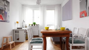 Meble jadalniane z pchlego targu gospodyni własnoręcznie odnowiła. Dębowy stół po zeszlifowaniu starego lakieru zaolejowała, a bukowe krzesła z oparciami z rafii pokryła białą lakierobejcą, zmieniła też ich tapicerkę. salon z jadalnią, meble z odzysku