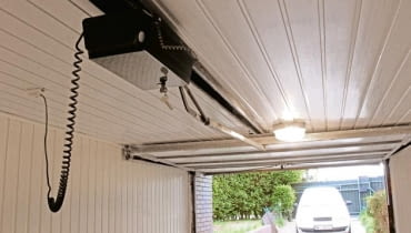 Napęd uchylnej bramy garażowej zamontowany pod sufitem garażu napęd do bramy garażowej