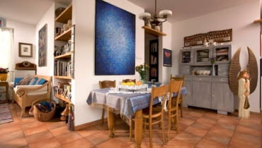 Mieszkanie. Gospodyni żartuje, że mieszka w muzeum osobliwości. Odnowione meble po przodkach zgodnie sąsiadują z pamiątkami z podróży po dalekich krainach. Czasem trudno się nawet domyślić, skąd pochodzi przedmiot - ze wsi pod lublinem czy z Patagonii. Kredens z rodzinnego domu gospodyni został przemalowany, zyskał też nowe szyby i porcelanowe gałki. Nad meblem wisi "Ludowe Wesele", dzieło ulubionego rzeźbiarza gospodyni - Antoniego Kamińskiego z Kutna. Fajansowe dzbanki na wino przyjechały z Wenecji. UWAGA ! PONOWNA PUBLIKACJA WYLACZNIE ZA ZGODA WLASCICIELI