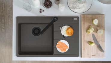 Franke zlewozmywak z czarnymi matowymi elementami i baterią.