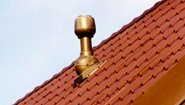 Wyrzutnia dachowa zużytego powietrza wentylacyjnego. Ten jeden mały komin zastępuje duże kominy murowane niezbędne do usuwania powietrza w domach z wentylacją grawitacyjną R