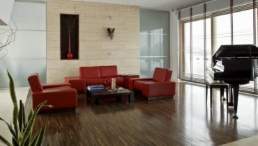 Trudno dokładnie przewidzieć wygląd podłogi z parkietu przemysłowego - dopiero po ułożeniu zobaczymy, jaką kompozycję stworzyły drewniane lamelki. W tym pomieszczeniu parkietem z egzotycznego drewna wenge wyłożono również dekoracyjną wnękę, w której stoi prosty ceramiczny wazon z gałęziami.