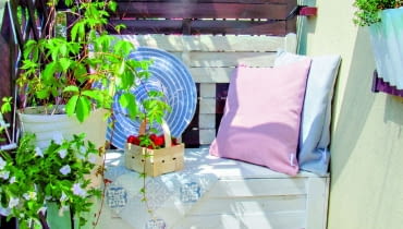 Oparcie balkonowej ławy zostało namalowane na drewnianym ekranie. Na pierwszym planie pomalowany na niebiesko wiekowy kociołek w roli donicy. Oparcie balkonowej ławy zostało namalowane na drewnianym ekranie. Na pierwszym planie pomalowany na niebiesko wiekowy kociołek w roli donicy.