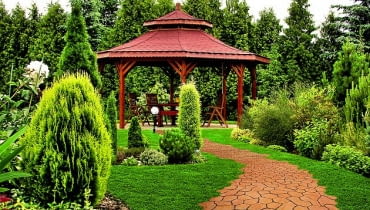 Kręta ścieżka z betonowych płyt o nieregularnej formie This is photo of summerhouse in the garden. Inside this build are chairs from the wood. That's fantastic place for barbecue and grill or relax.