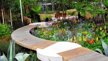 ŚCIEŻKA- -POMOST z prostokątnych bali ułożonych na styk. W połączeniu z betonowymi detalami dodaje ogrodowej kompozycji dynamiki. ŚCIEŻKA- -POMOST z prostokątnych bali ułożonych na styk. W połączeniu z betonowymi detalami dodaje ogrodowej kompozycji dynamiki.