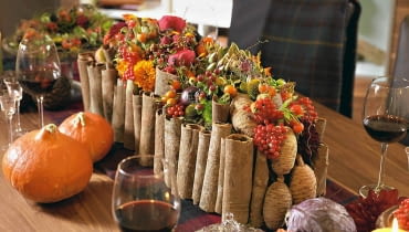 Kompozycje kwiatowe. Stroik w angielskim stylu. W otoczce z cynamonowej kory ozdobionej cedrowymi szyszkami - zwarta kompozycja z dalii, róż, aksamitek, krokosmii, owoców karczocha, róży, granatu, kaliny Kompozycje kwiatowe. Stroik w angielskim stylu. W otoczce z cynamonowej kory ozdobionej cedrowymi szyszkami - zwarta kompozycja z dalii, róż, aksamitek, krokosmii, owoców karczocha, róży, granatu, kaliny