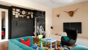 <B>SALON</B>. Na ścianę naklejono fototapetę ze zdjęciem dzieci gospodarzy mieszkania. Ścianę obok fototapety pomalowano magnetyczną farbą tablicową. Taka ściana nie musi służyć wyłącznie zabawie - może np. pełnić funkcję domowej tablicy ogłoszeniowej. salon, aranżacja salonu, farba tablicowa