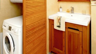 <b> SCHOWEK ZA ŚCIANKĄ. Lekka ścianka z drewna przesłoniła pralkę i wiszący nad nią piec z przyłączami. Dostęp do urządzeń jest nadal wygodny, a łazienka znacznie zyskała na wyglądzie. </b> <BR /> Ściankę zrobiono z gotowych sosnowych drzwi lamelkowych, które zabarwiono bejcą. Zostały tak zamocowane, by w razie potrzeby łatwo dało się je zdemontować.