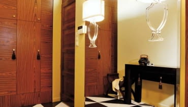 1. Minipałacyk. Architektka, zainspirowana wzorami podłóg często spotykanych w pałacach, zaprojektowała "wariację na temat" z połówek gresowych płytek w czekoladowym i kremowym odcieniu. Do kompletu zaproponowała równie stylową szafę wnękową fornirowaną palisandrem, z zabawnymi chwościkami przy uchwytach. Gospodyni uzupełniła wystrój meblami w stylu kolonialnym - dobrała m.in. stolik kojarzący się z pałacową konsolką - oraz lampami... unoszącymi się w powietrzu. Iluzja jest w każdym razie doskonała. W rzeczywistości kinkiety z płaską nóżką przymocowano do lustra zajmującego niemal całą ścianę. 1. Minipałacyk. Architektka, zainspirowana wzorami podłóg często spotykanych w pałacach, zaprojektowała "wariację na temat" z połówek gresowych płytek w czekoladowym i kremowym odcieniu. Do kompletu zaproponowała równie stylową szafę wnękową fornirowaną palisandrem, z zabawnymi chwościkami przy uchwytach. Gospodyni uzupełniła wystrój meblami w stylu kolonialnym - dobrała m.in. stolik kojarzący się z pałacową konsolką - oraz lampami... unoszącymi się w powietrzu. Iluzja jest w każdym razie doskonała. W rzeczywistości kinkiety z płaską nóżką przymocowano do lustra zajmującego niemal całą ścianę.