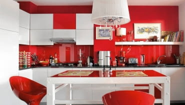 <B>Nie byłam zwolenniczką otwartych kuchni. Nie przekonywały mnie nawet argumenty, że to najprostszy sposób na uzyskanie sporej przestrzeni dziennej w niewielkim mieszkaniu. Moje wątpliwości rozwiały dopiero projekty, w których częściowo oddzielono kuchnię od salonu. Właśnie takie pokazujemy.</B> <BR />PULS DOMU. Życie rodzinne i towarzyskie skupia się tutaj w kuchni, dlatego gospodarze postanowili w żaden sposób jej nie przesłaniać. Wręcz przeciwnie - dzięki wyrazistej aranżacji wyeksponowali wnętrze i nadali mu rangę najważniejszego aneksu w otwartej strefie dziennej. <BR />W kuchni przyciąga wzrok kontrastowe zestawienie dwóch barw. Pomalowane na czerwono ściany zabezpieczono nad blatem roboczym taflą hartowanego szkła. Większość szafek jest biała, tylko gdzieniegdzie wstawiono czerwone fronty, które ożywiają ich jednolitą powierzchnię.