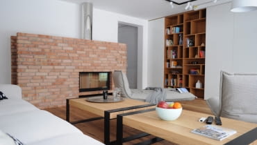 Spójnym elementem na dolnej kondygnacji jest stara cegła. Widać ją nie tylko w jadalni, ale też w salonie, gdzie tworzy oprawę dużego kominka. dom, kolorowy dom, dom pełen kolorów, mysłowice