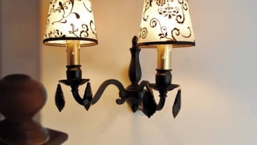 W stylu glamour. Podniszczony mosiężny kinkiet, jakich wiele można znaleźć na targach staroci, łatwo odmienić, nadając mu tak modny ostatnio styl glamour. Trzeba tylko kupić ładne abażury, wisiorki z kryształu bądź imitującego go plastiku oraz trochę farby. Koszt: 100 zł