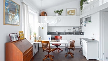 Otwarta kuchnia jest częścią strefy dziennej. Są w niej proste białe szafki (zrobione przez firmę z Mławy) oraz meble, które pasują stylem również do salonu: krzesła biurowe z Ameryki i biała szafka z targu staroci. Na podłodze - dąb olejowany. Blat i pas kamienia na ścianie to chiński granit. Sposób na oszczędności: stół to pomalowana na biało płyta OSB, do której przykręcono metalowe nogi z dawnego biurka córki. Otwarta kuchnia jest częścią strefy dziennej. Są w niej proste białe szafki (zrobione przez firmę z Mławy) oraz meble, które pasują stylem również do salonu: krzesła biurowe z Ameryki i biała szafka z targu staroci. Na podłodze - dąb olejowany. Blat i pas kamienia na ścianie to chiński granit. Sposób na oszczędności: stół to pomalowana na biało płyta OSB, do której przykręcono metalowe nogi z dawnego biurka córki.