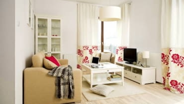 Aranżacja. Monika i Marcin obawiali się, że urządzanie nowego mieszkania zajmie im długie miesiące. Tymczasem wystarczyło podjąć jedną decyzję - skorzystać z usługi wykończenia zaproponowanej przez dewelopera. Dzięki temu wprowadzili się do gotowego wnętrza, które czekało na nich w bloku pod Warszawą. Sami wybrali tylko dodatki. Wiejska tradycja połączona z miejską współczesnością - taki pomysł na wykończenie wnętrza miała architektka Kamila Chorzelewska. W mieszkaniu dominuje ciepła, pastelowa kolorystyka, która w połączeniu z jasnym drewnem tworzy klimat sprzyjający wypoczynkowi - a tego właśnie potrzebują właściciele (Monika pracuje w firmie doradczej, Marcin jest trenerem w klubie sportowym). Pokój dzienny, tak jak pozostałe pomieszczenia, zaaranżowano w odcieniach bieli, beżów i écru; tylko gdzieniegdzie pojawiają się czerwone akcenty. Tuż za oknem zieleni się wymarzony ogródek, nieco dalej rozpościera się Las Kabacki. UWAGA ! PONOWNA PUBLIKACJA WYLACZNIE ZA ZGODA WLASCICIELI