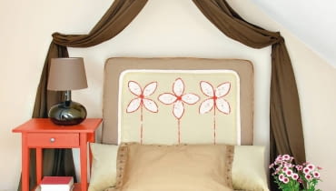 Nie wystarczy wygodny materac, by w łóżku czuć się naprawdę komfortowo. Przydaje się też miękki zagłówek, a niestety nie każde łóżko jest w niego wyposażone. Pokazujemy trzy proste sposoby, jak go samodzielnie zrobić. Przy takim wsparciu przyjemność wieczornej lektury lub seansu filmowego będzie jeszcze większa. <BR />W kwiatach - odpowiedniej wielkości gąbkę tapicerską grubości mniej więcej 8 cm obszywamy płótnem w kolorze dopasowanym do wystroju wnętrza. W dolnej części warto wszyć suwak lub rzepy, żeby pokrowiec można bylo łatwo zdejmować do prania.
