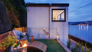 Domek nocą. Mały, ale wygodny domek nad brzegiem morza